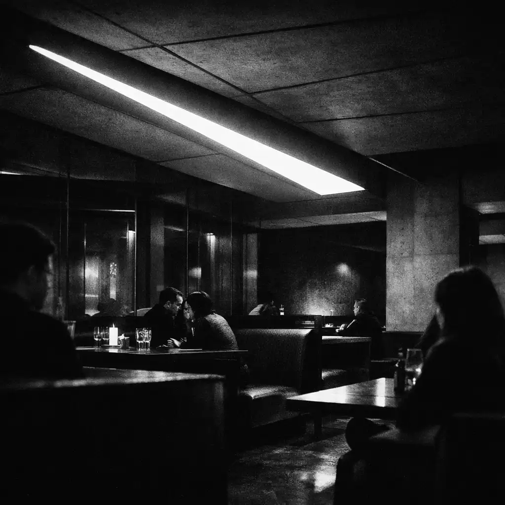 Angular lights, dark seating, glass reflections, and cropped silhouettes in the underground venue.